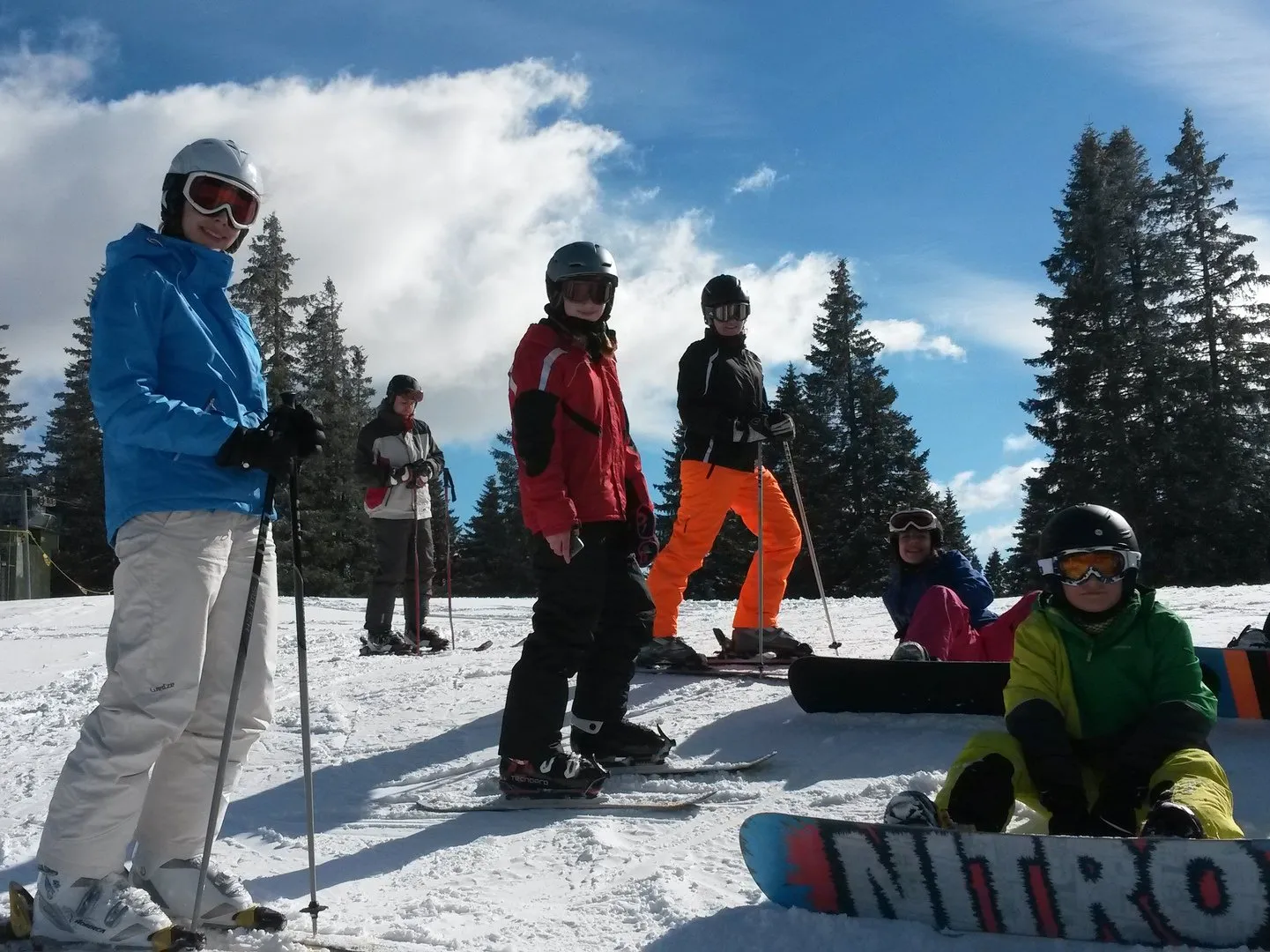 Ski- und Snowboardfahrer machen Pause an einem Hang