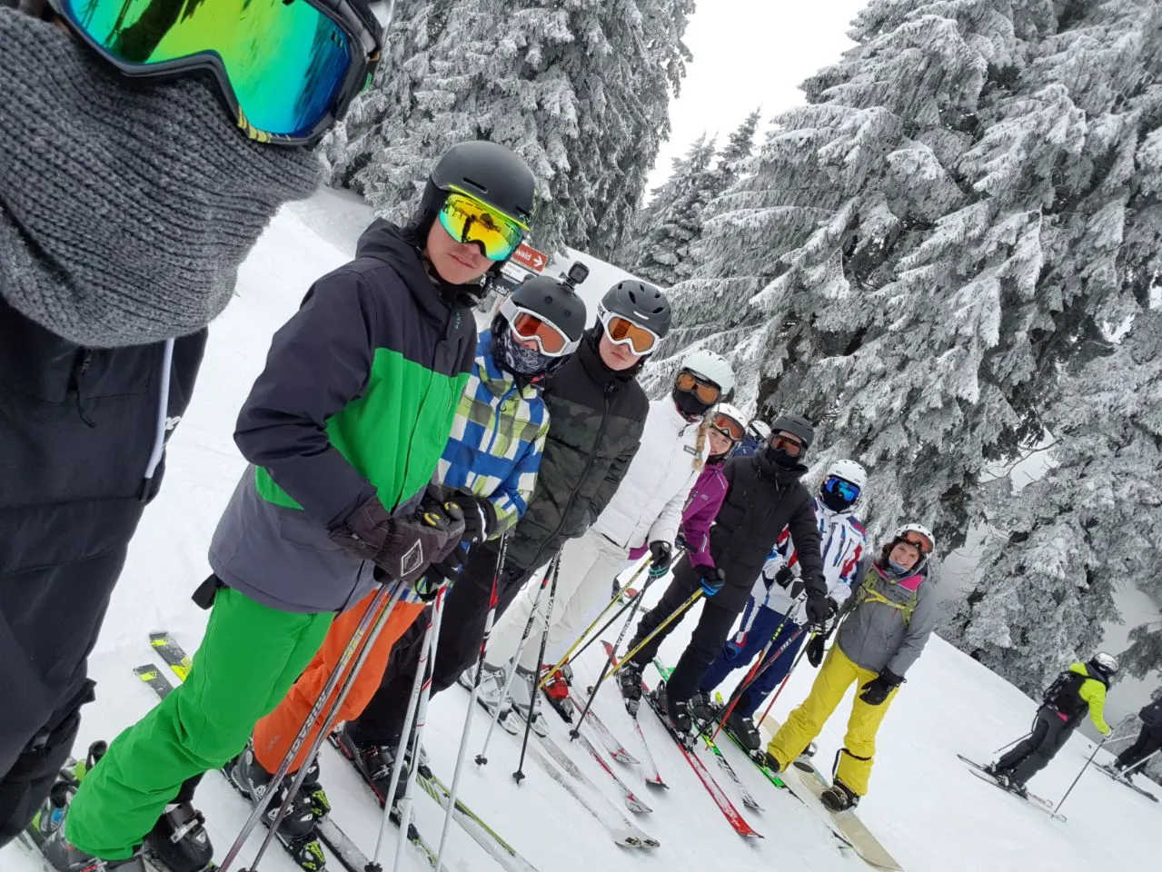 Viele Skifahrer stehen nebeneinander im Schnee